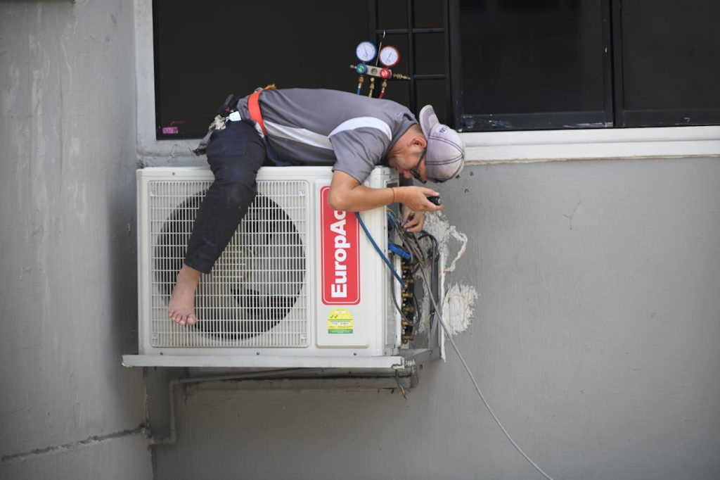 Técnico realizando manutenção de ar-condicionado residencial.