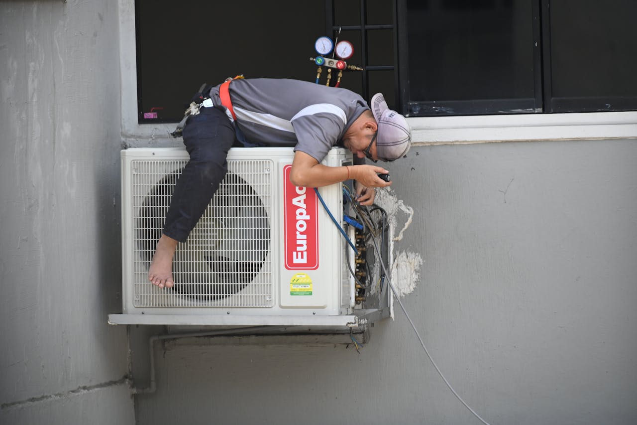 Técnico realizando manutenção de ar-condicionado residencial.